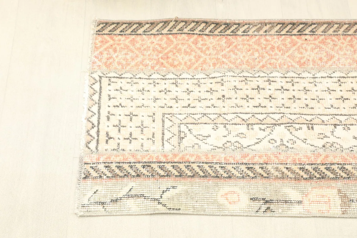 Overhead shot of one end of the rug, showing the distinct orange and cream patterned panels.