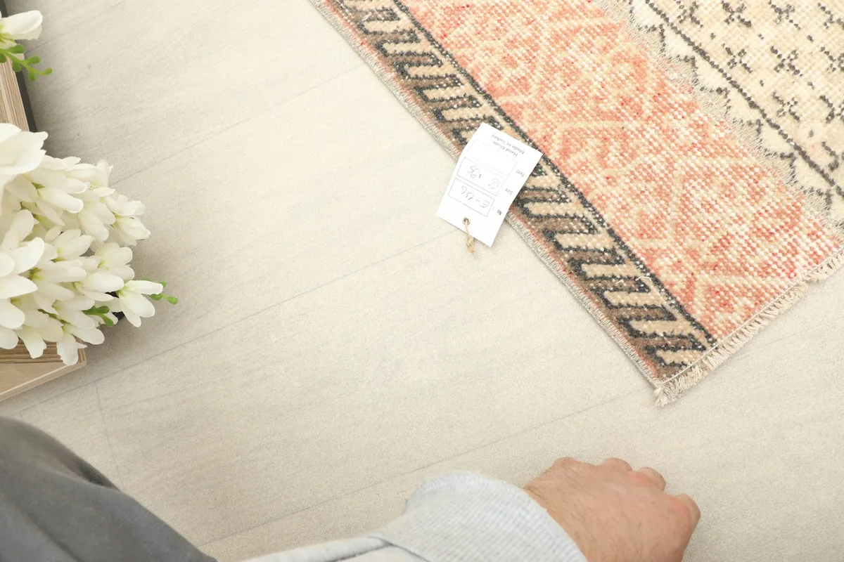 Close-up of the rug's label, confirming its origin and material, next to the rug's edge.