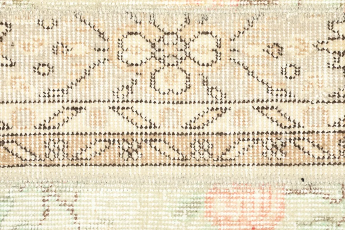 Detailed view of the central geometric motifs and borders, showing the hand-knotted wool pile.