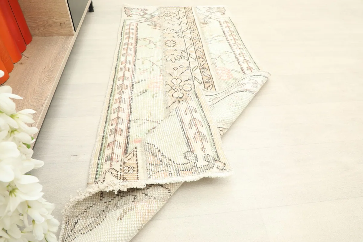 The runner rug partially folded, demonstrating its pliable structure and how it lays on the floor.
