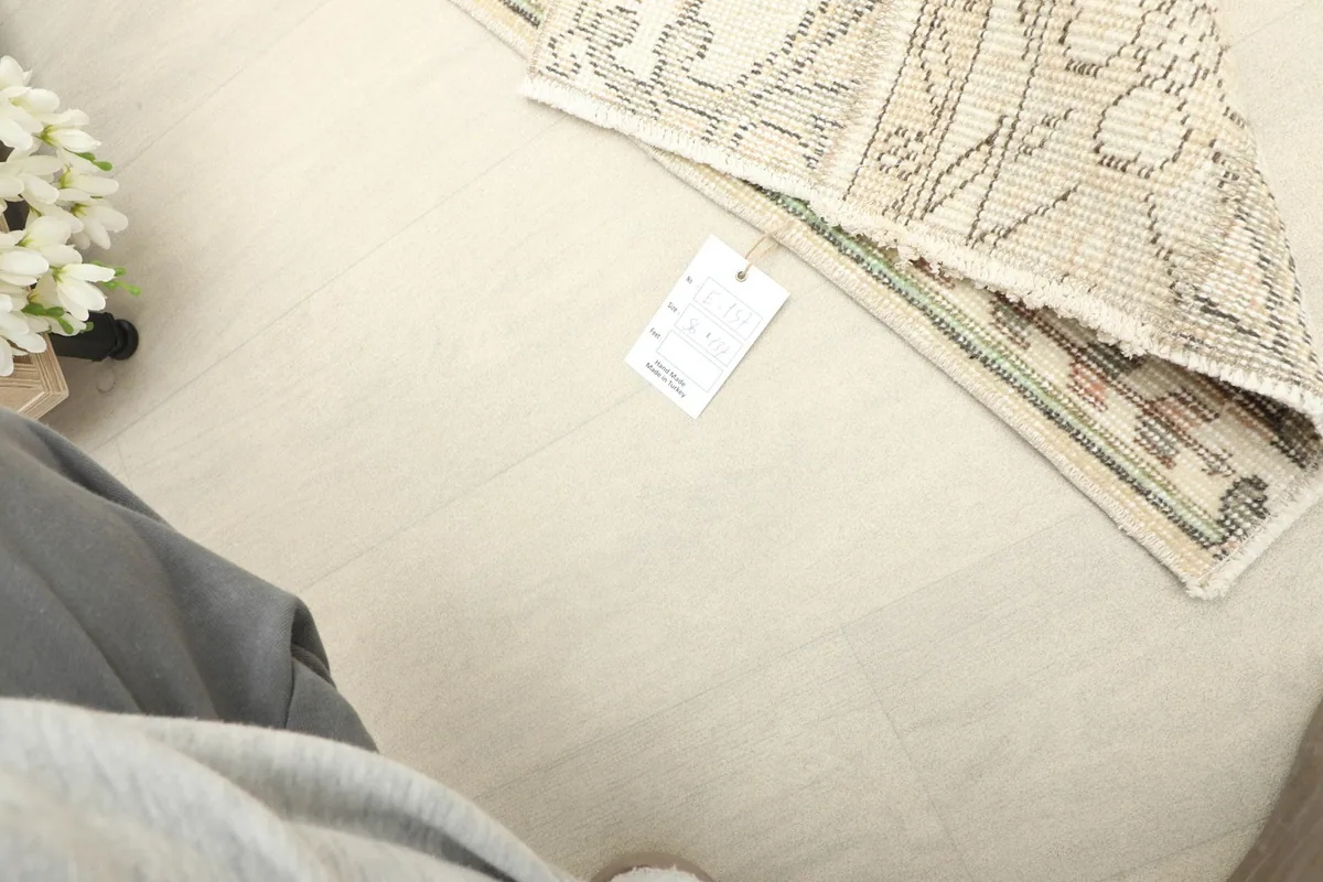 A close-up view showing the rug's tag with product information, alongside a corner of the rug.