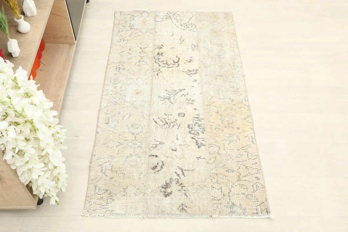 Overhead view showing the complete design and subtle color variations of the beige wool rug.