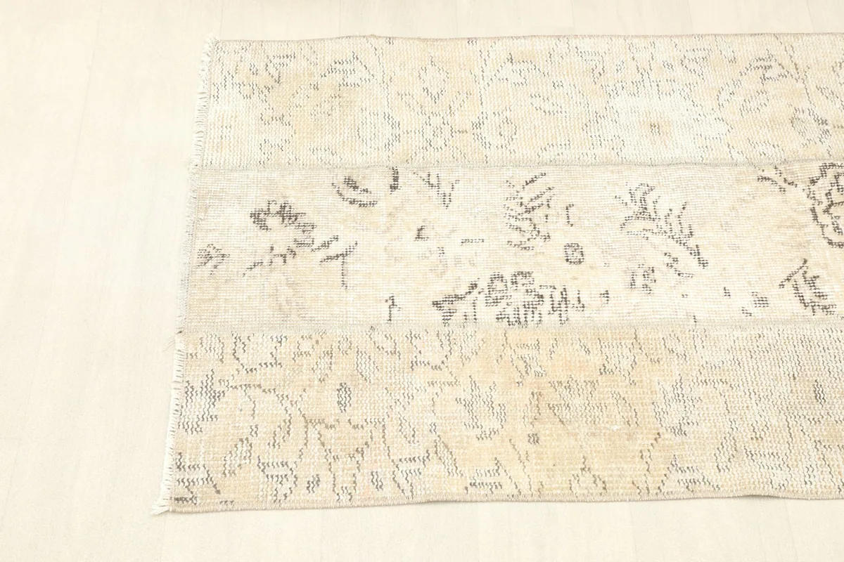 Overhead partial view of the rug, focusing on the varied pattern sections and natural patina.