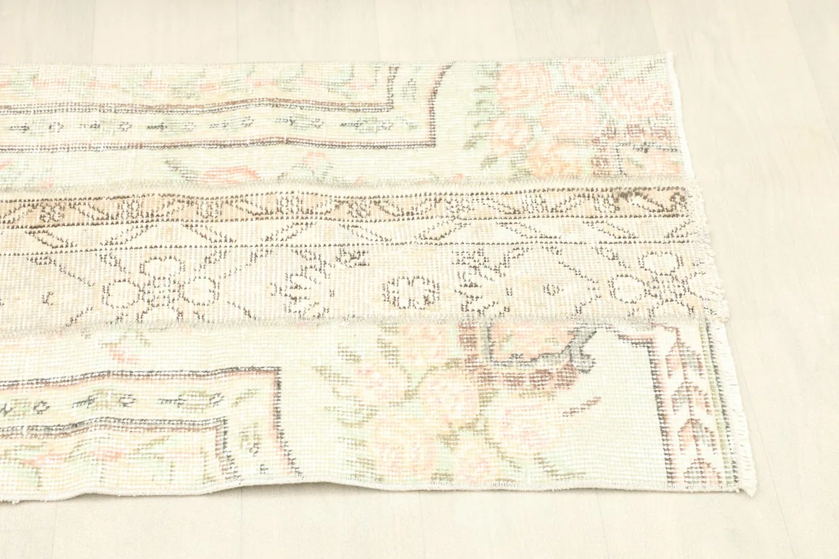 Another angled view, emphasizing the faded pink and green floral designs integrated into the patchwork style.