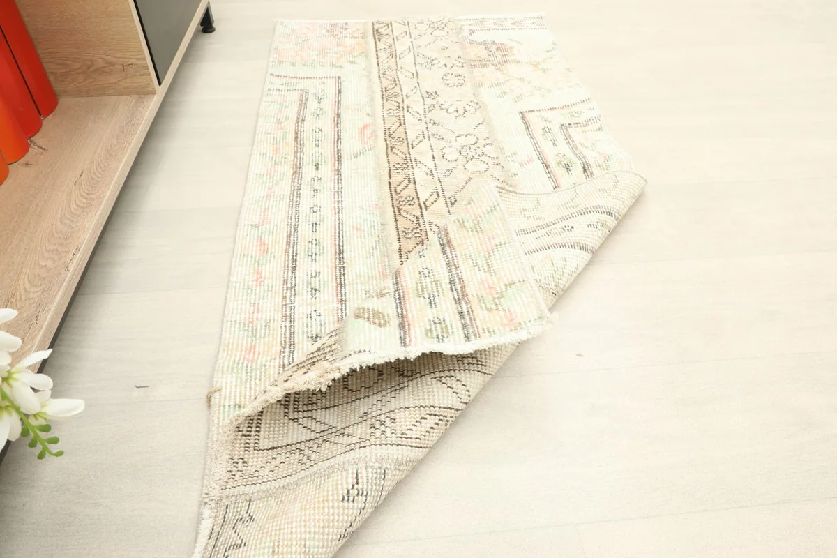 The rug folded back, displaying the sturdy cotton foundation and the reverse side of the hand-knotted construction.