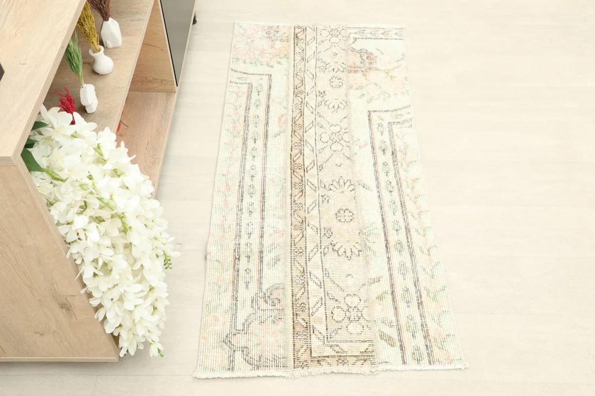 Overhead view of the ivory rug, highlighting the varied floral and geometric patterns across its surface.