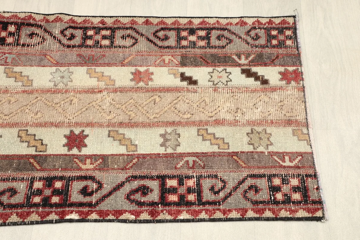 Another partial view of the rug, showing the opposite side's border and the full range of stripe colors
