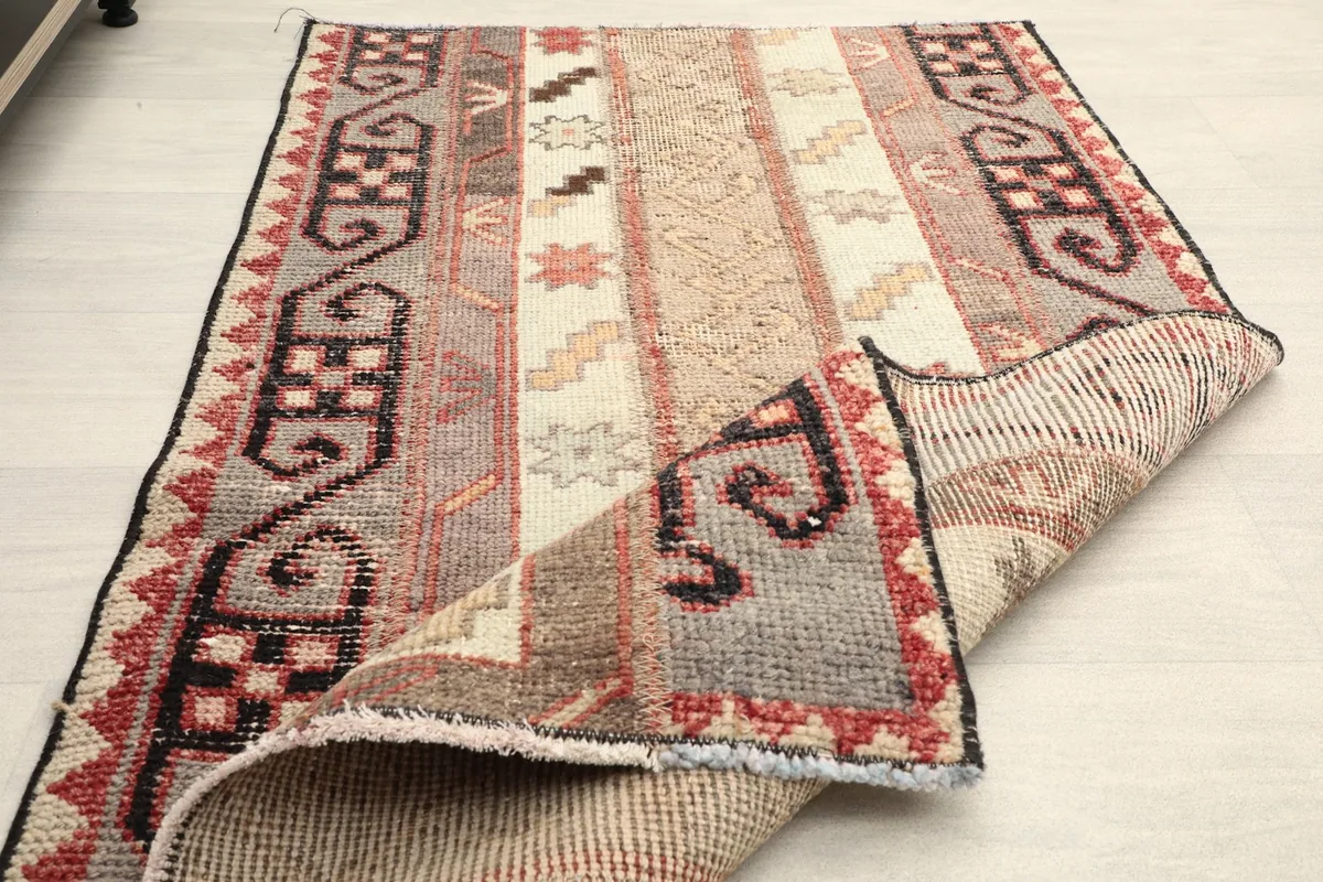 Rug partially folded to show its flexibility and thickness, displaying the back and front