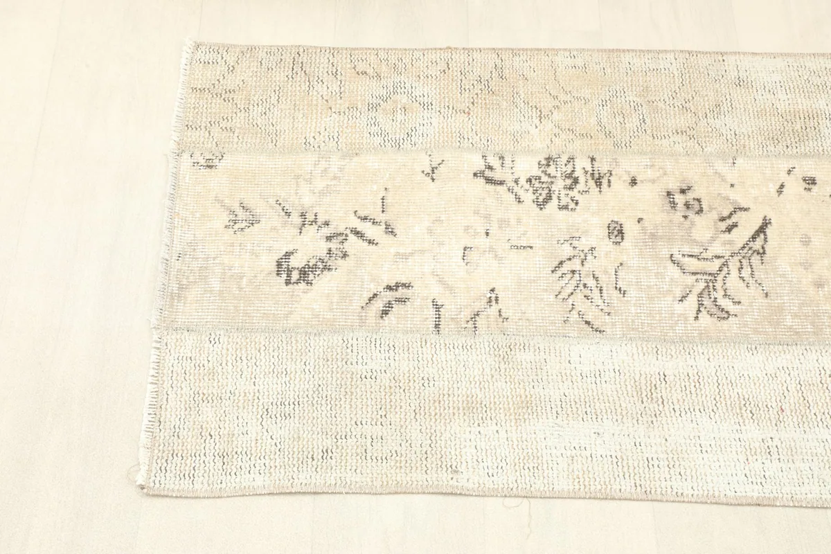 View of one end of the rug, showing the blend of central patterns and outer faded designs.