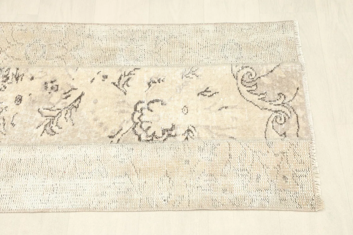 View of the opposite end, revealing the continuation of the distressed beige and charcoal patterns.