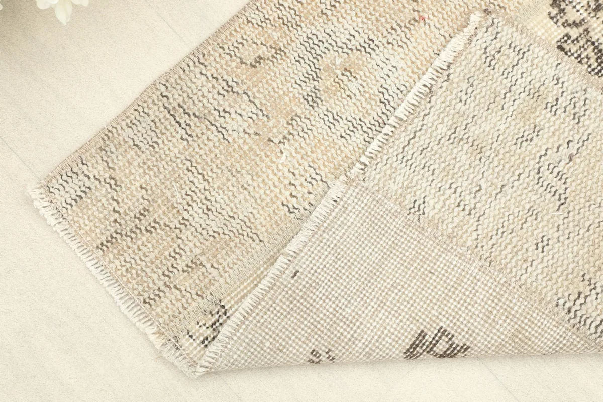 Corner of the rug folded to show the hand-knotted wool pile on cotton foundation.