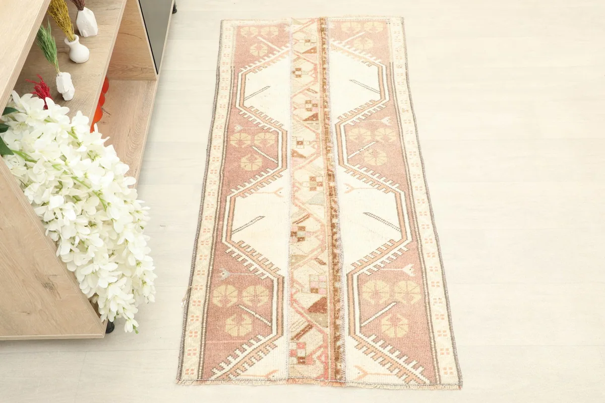 Overhead view of the rose and beige hand-knotted wool rug, showing full pattern.