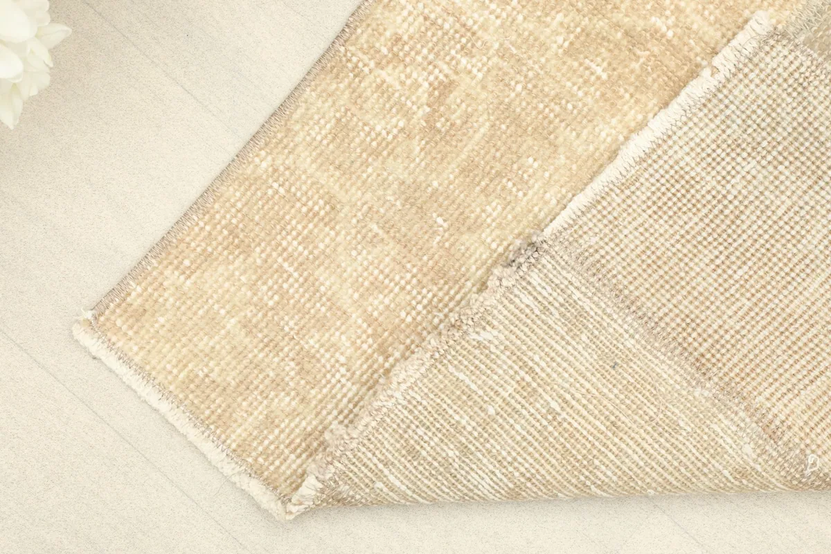 View of the rug's underside, revealing the cotton foundation and hand-knotting.