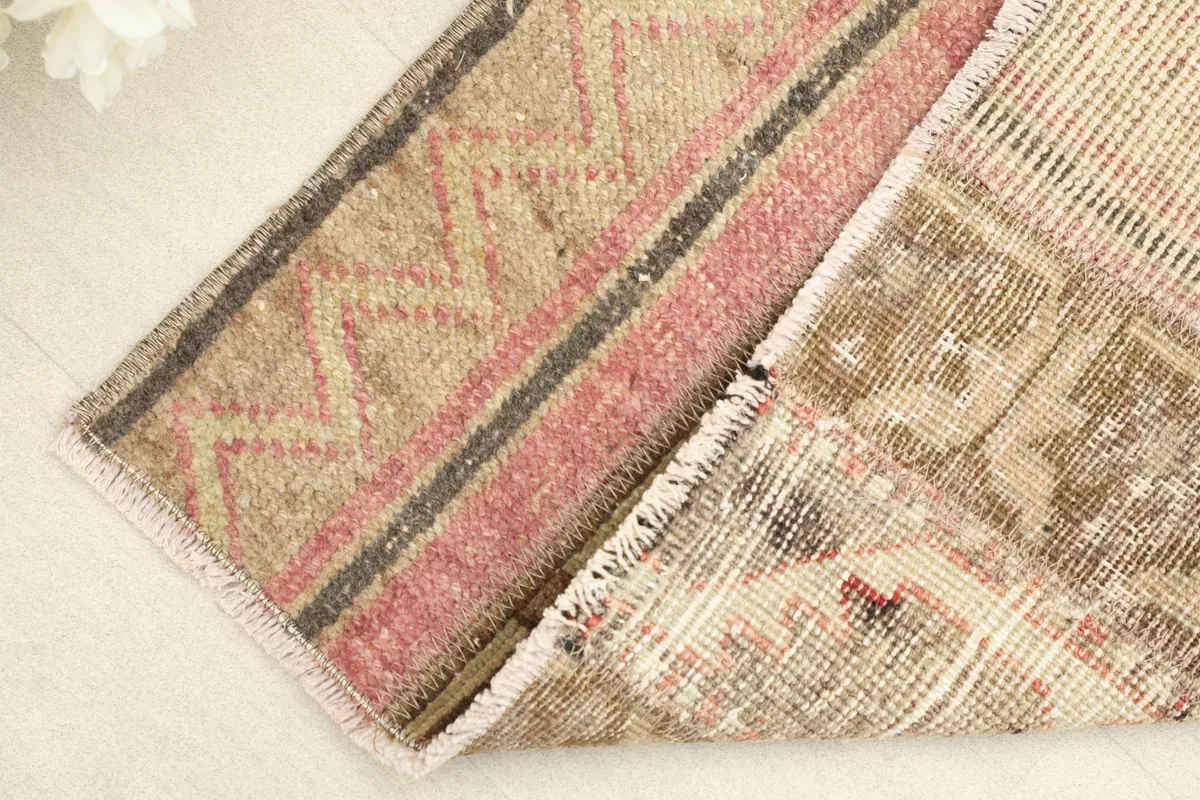 Corner of the rug folded to reveal the cotton foundation and the reverse side of the hand-knotted pile.