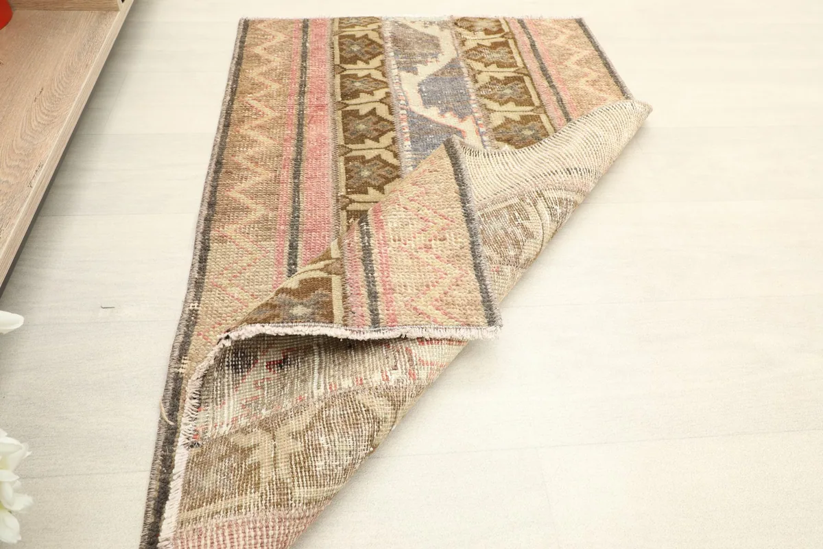Rug partially folded, displaying both the top surface with its patterns and the sturdy cotton foundation.