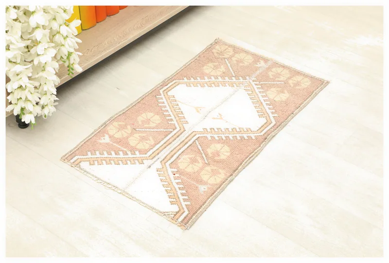 Full top view of the 1x2 rose and ivory tribal geometric vintage rug on a white background.
