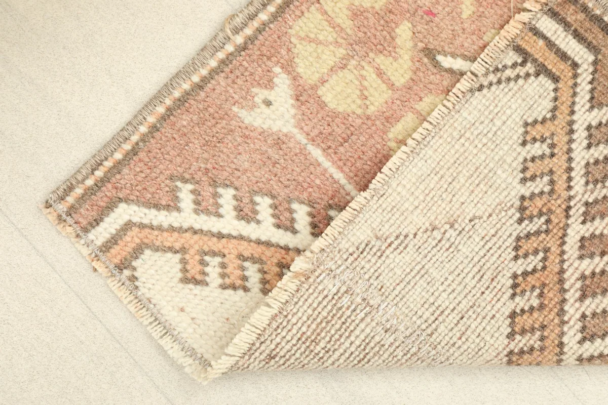 View of the rug's cotton foundation and the reverse side of the hand-knotted wool pile.
