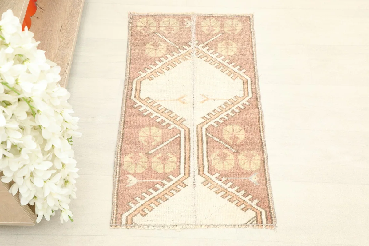 Overhead view of the vintage Anatolian rug, showing its complete rose field and ivory geometric patterns.