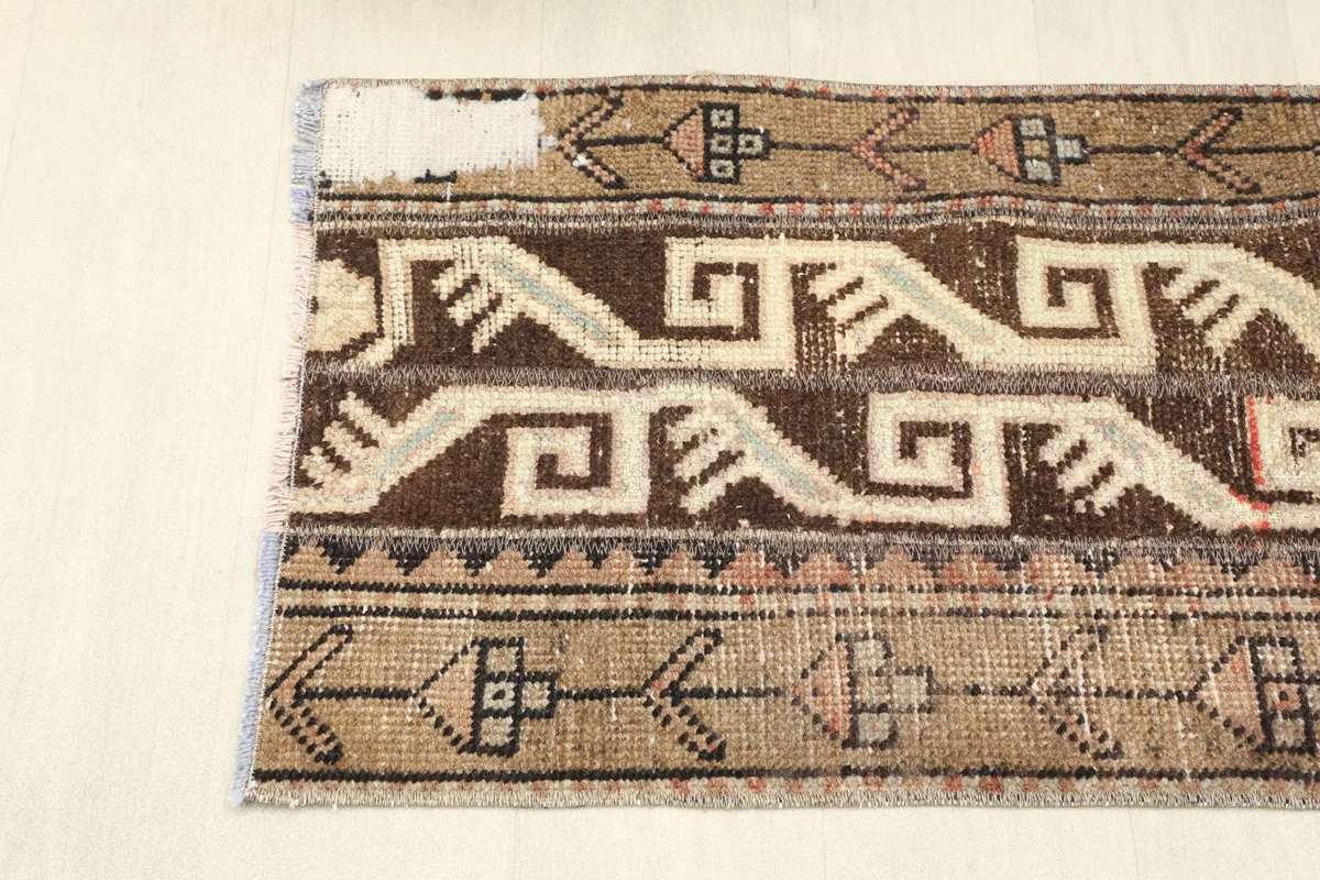 Close-up of one end of the rug, showing the outer border design and edge wear.