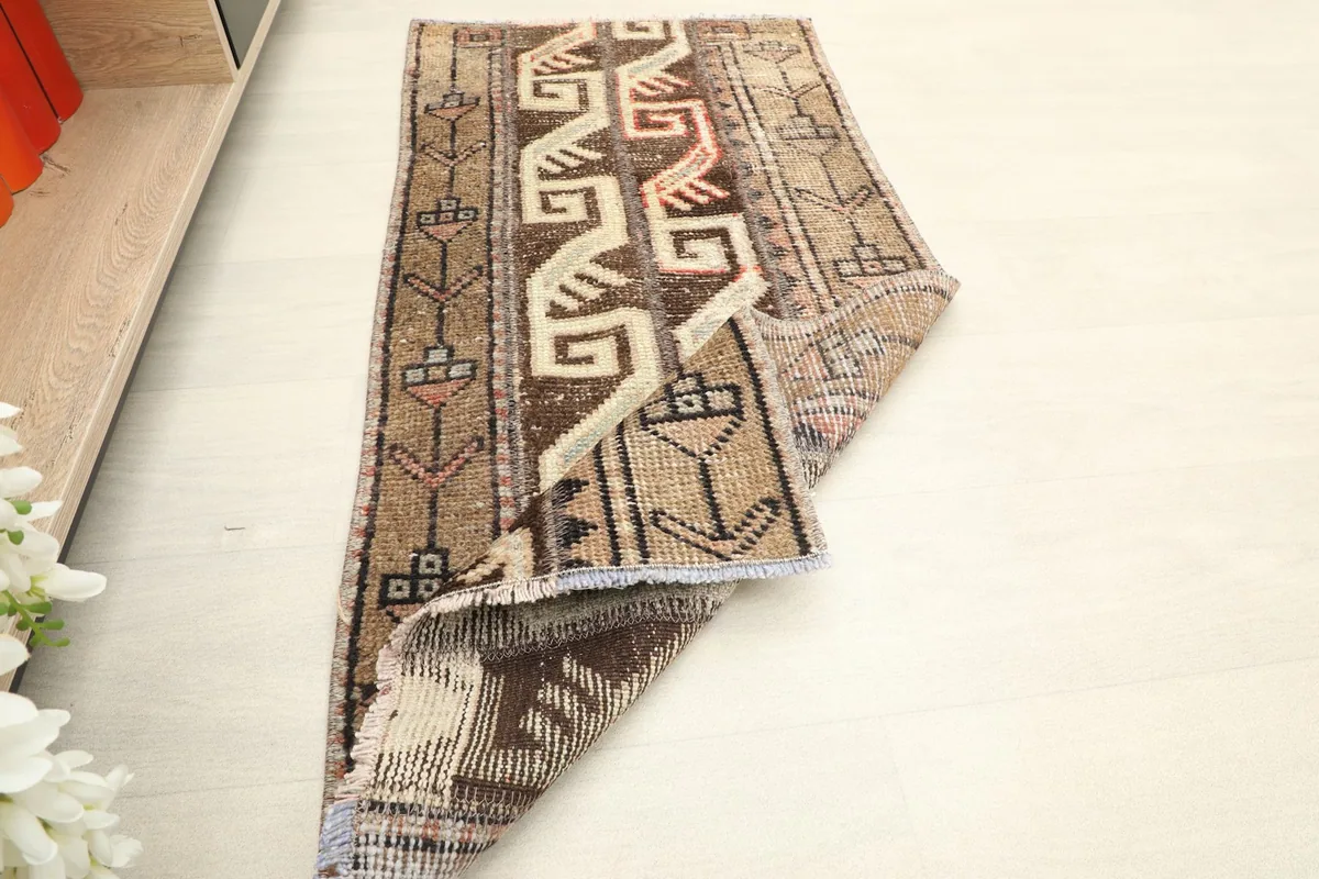 Rug partially rolled up, showing its flexibility and the overall design from an elevated angle.