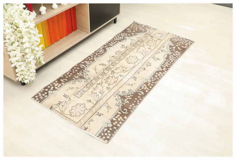 Full overhead view of the beige and brown vintage Anatolian area rug on a light floor.