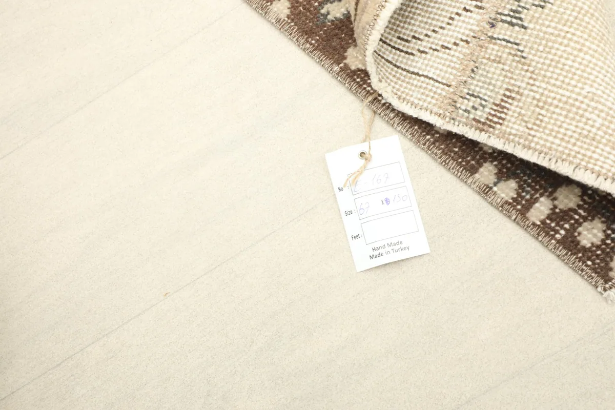 Close-up of the rug's reverse side with a product tag, displaying the hand-knotted cotton foundation.