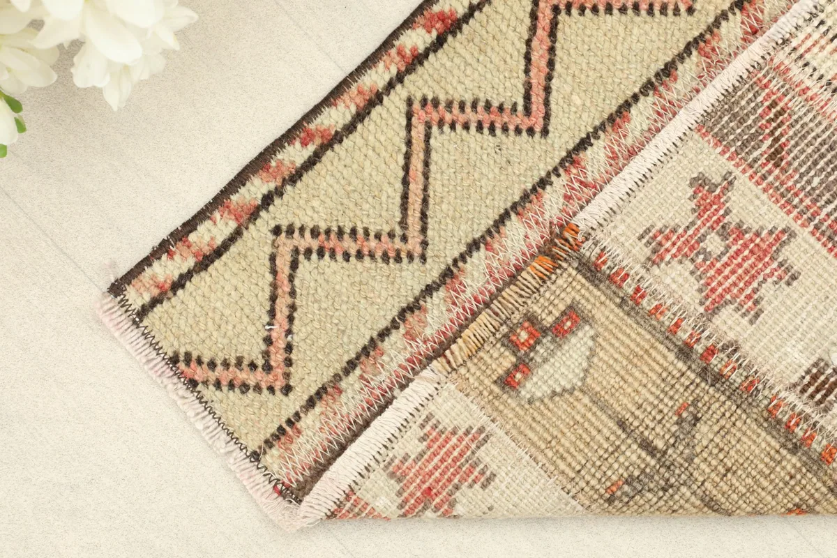 Folded corner of the rug, showing the reverse side and the texture of the hand-knotted wool.