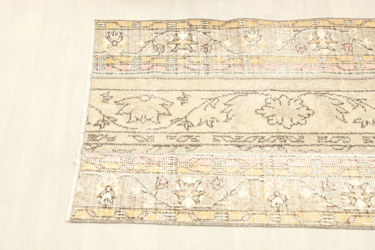 Angled view of the rug's left side, showing the distinct patchwork sections and subtle colors.