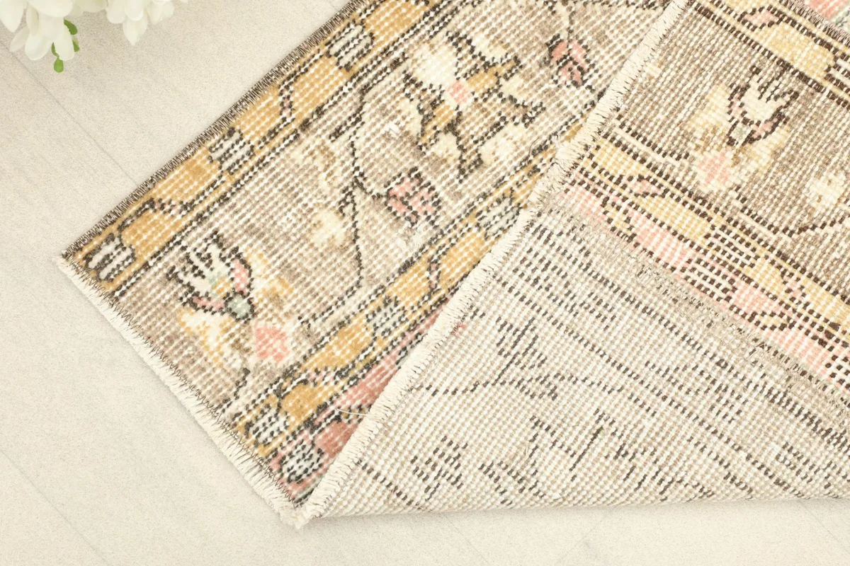 Corner view showing the front and back of the hand-knotted wool rug, revealing its foundation.