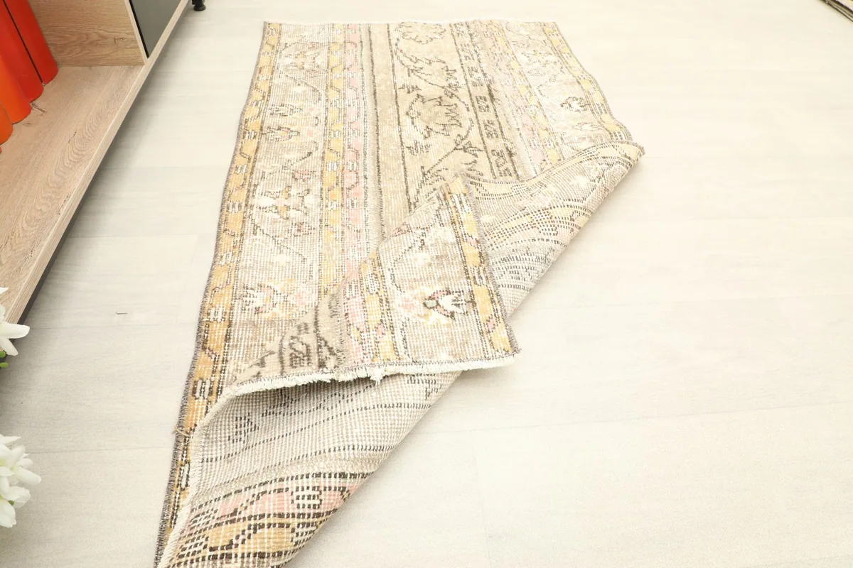 The rug folded to show its flexibility and the reverse side, with a light colored fringe.