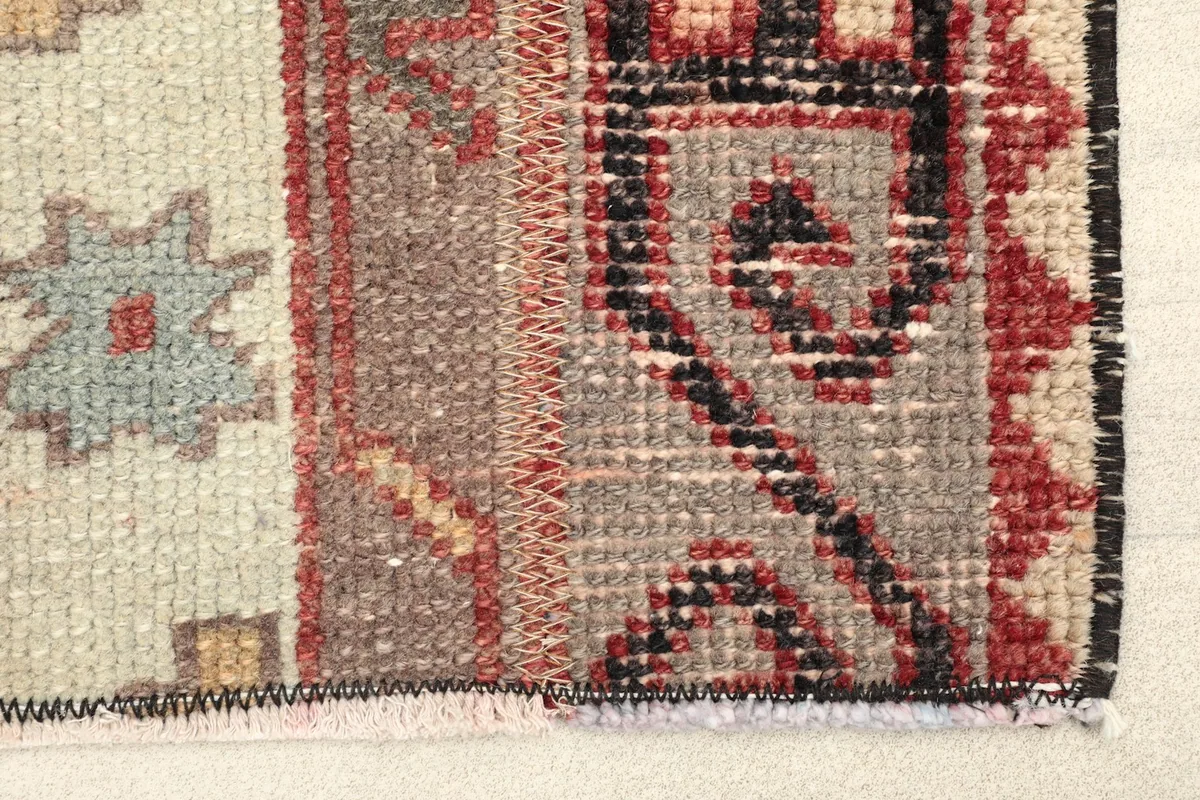 Close-up detail of the rug's border and central striped motifs with red and black accents
