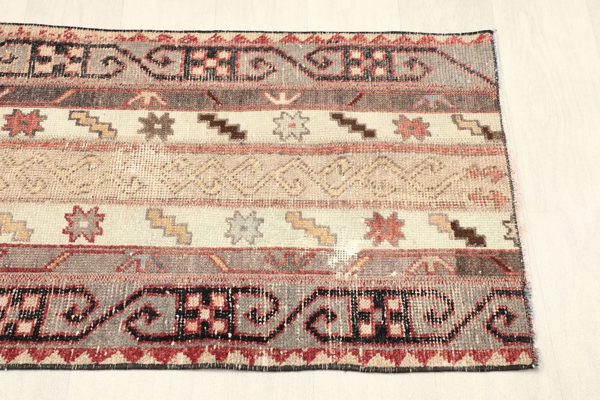 View of the opposite short side of the rug, showing slight patina and design consistency