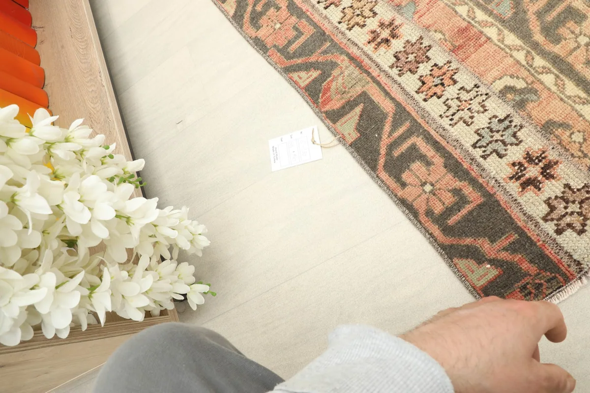 Partial view of the rug in a home setting, showing its scale next to furniture