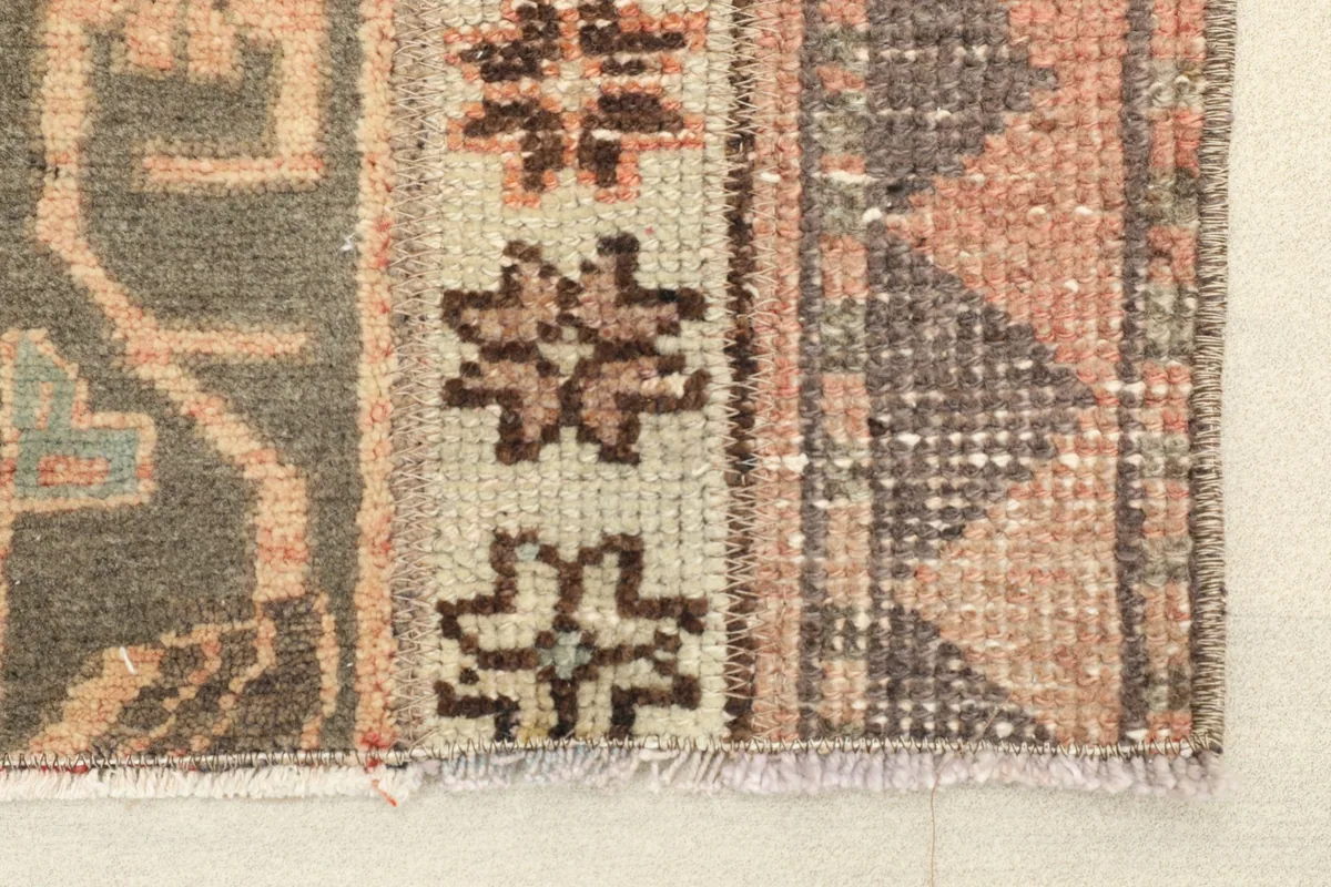 Close-up of the rug's end, showing the geometric patterns and fringe detail