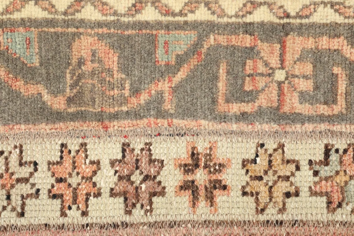 Detailed view of a gray band with geometric motifs and a beige band with star-like patterns