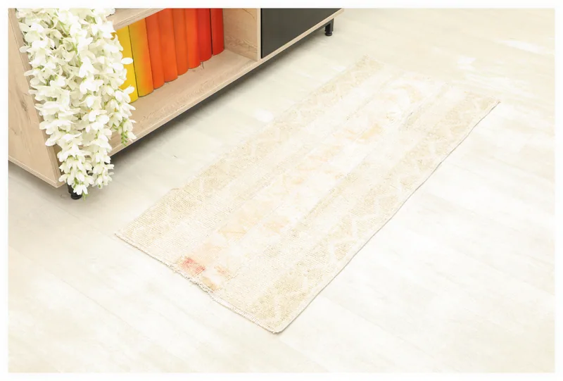 Full top view of the 1'9" x 4'0" ivory and rose patchwork rug on a light floor.