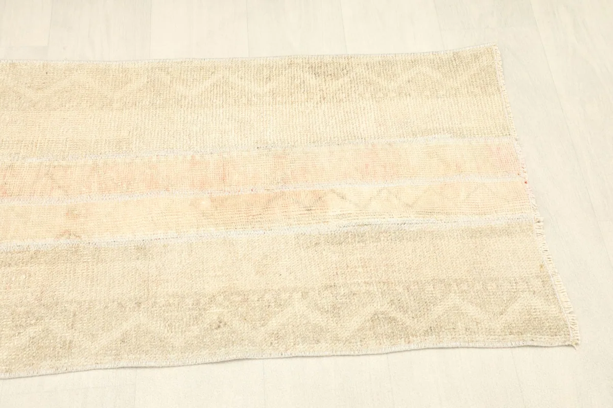 Angled shot of the rug's other end, showcasing the consistent patchwork style and gentle wear.