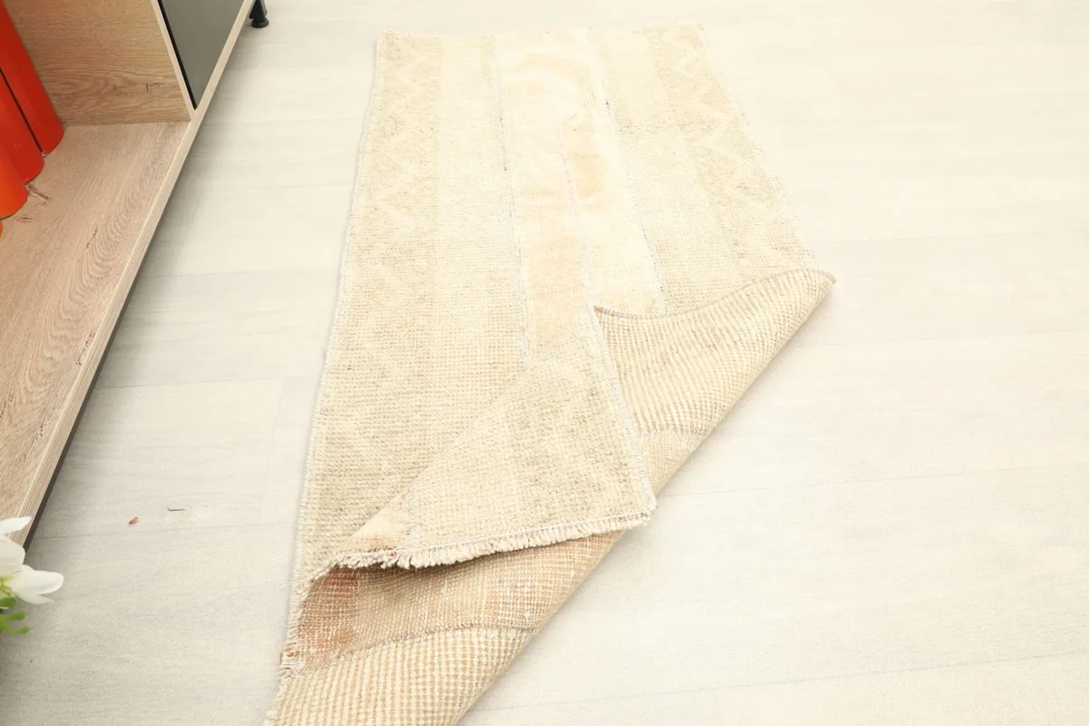 Rug partially folded, illustrating its flexibility and the thickness of the hand-knotted construction.