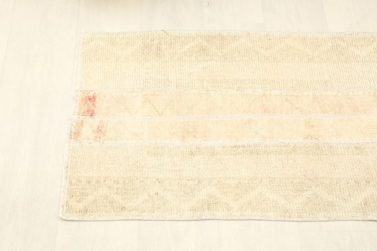 Top-down view of the rug's mid-section, revealing the subtle geometric designs within the ivory panels.