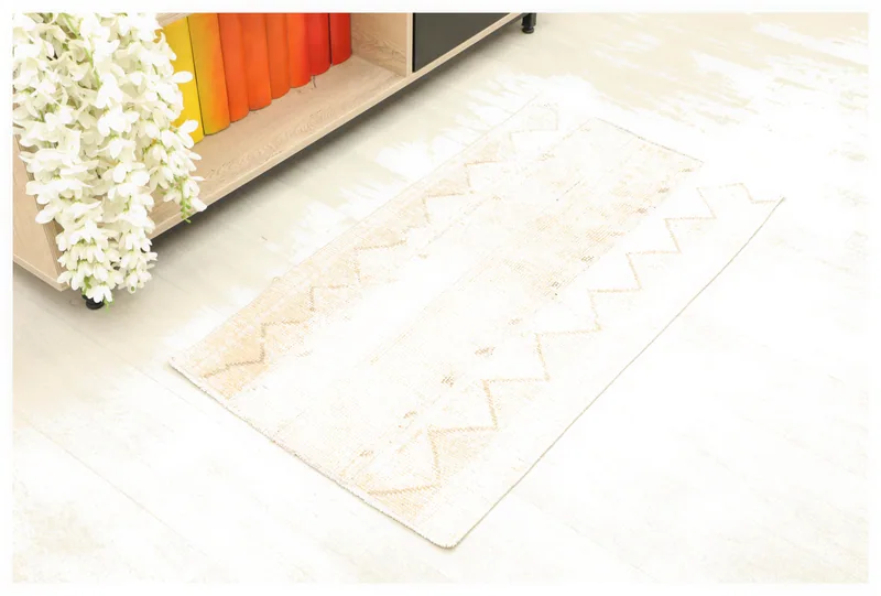 Full overhead view of the ivory and tan geometric vintage Anatolian rug on a white background.
