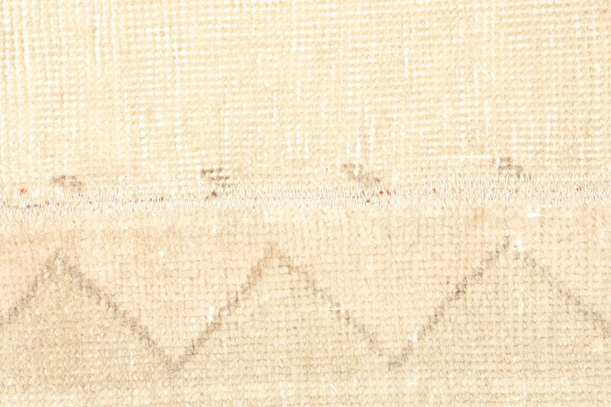 Close inspection of the low wool pile and the intricate hand-knotted weaving of the rug.