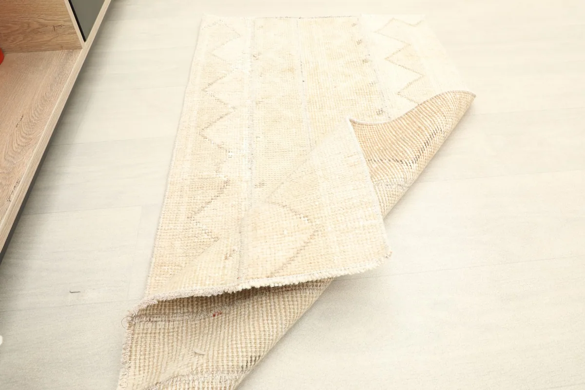 Rug partially folded, displaying both the front design and the sturdy construction of the back.