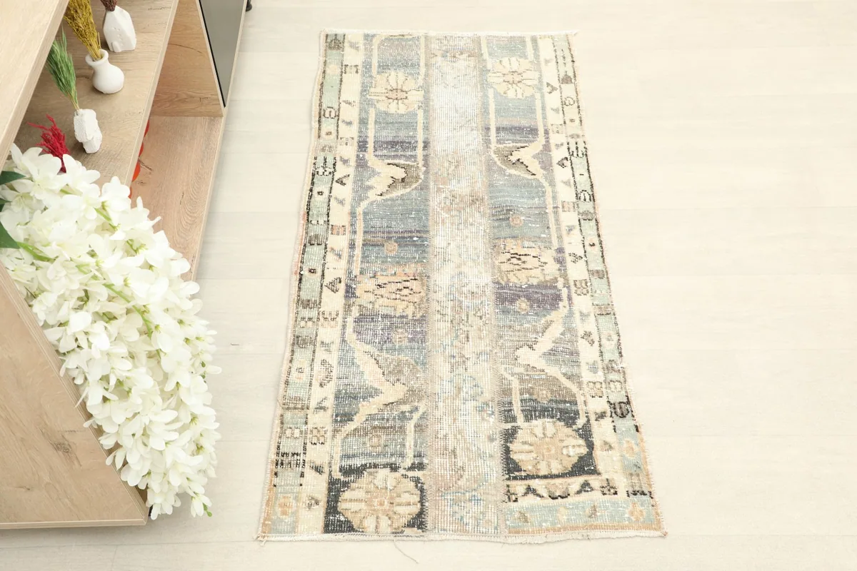 Overhead view of the hand-knotted vintage rug, showing its blue, gray, and cream color palette.