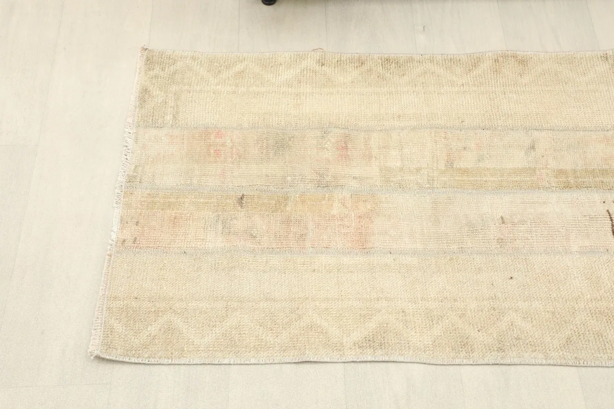 View of the end of the runner, showing faded geometric border patterns and fringe