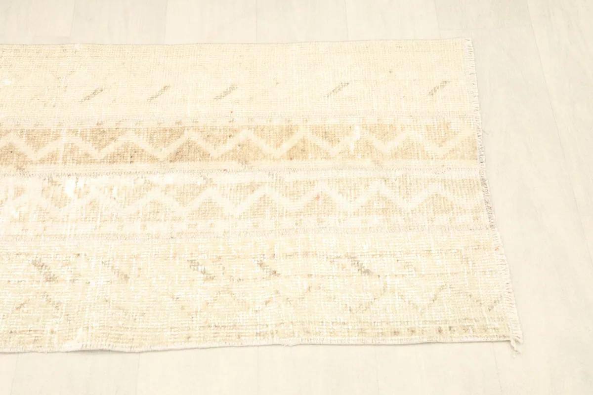 Angled view of the other end of the rug, showing the consistent vintage wear and design.