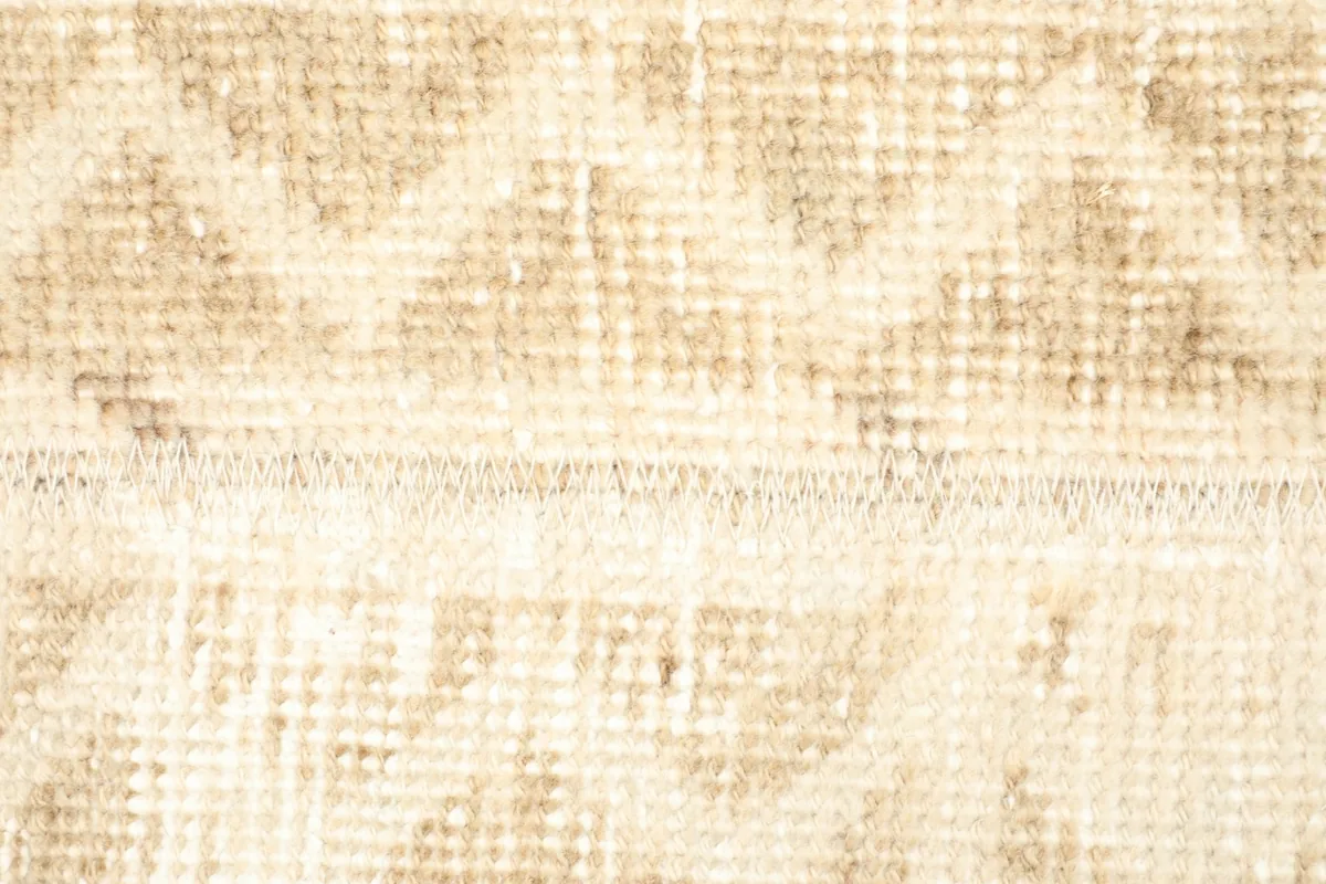 Extreme close-up showing the low wool pile, hand-knotted texture, and color variations.