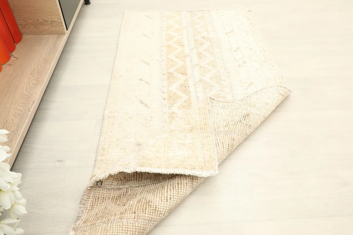 Rug partially folded, showing the flexibility and thickness of the vintage hand-knotted piece.