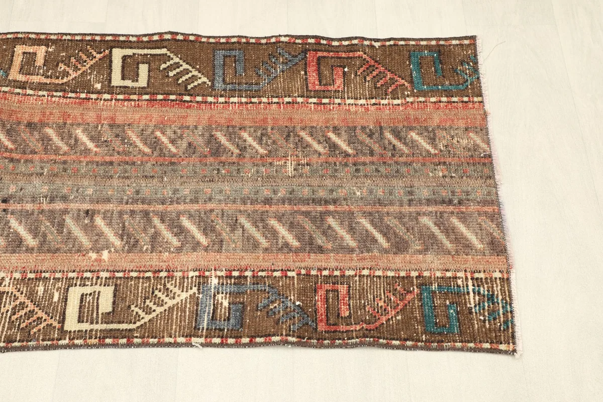 Detail of the opposite side of the rug, showcasing the intricate border designs and color palette.