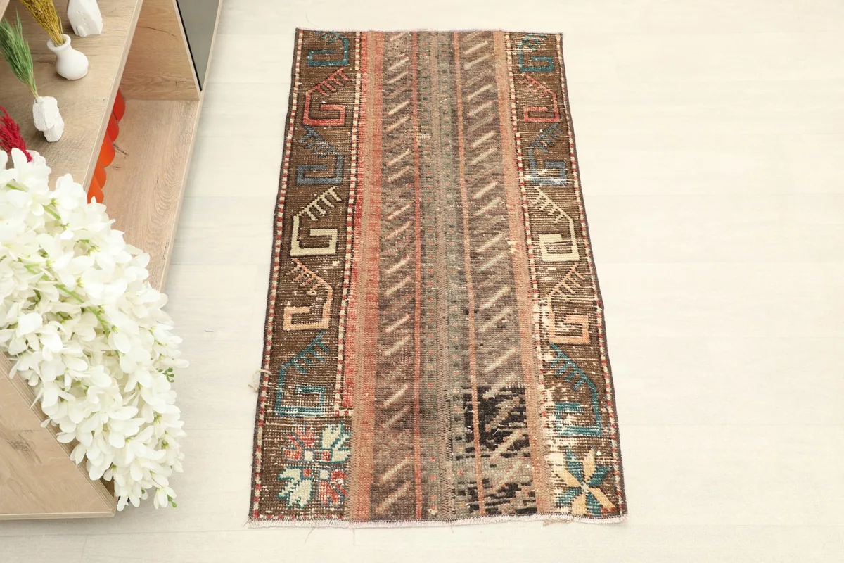Overhead view of the vintage Anatolian rug, highlighting its rich brown and rust tones and tribal motifs.