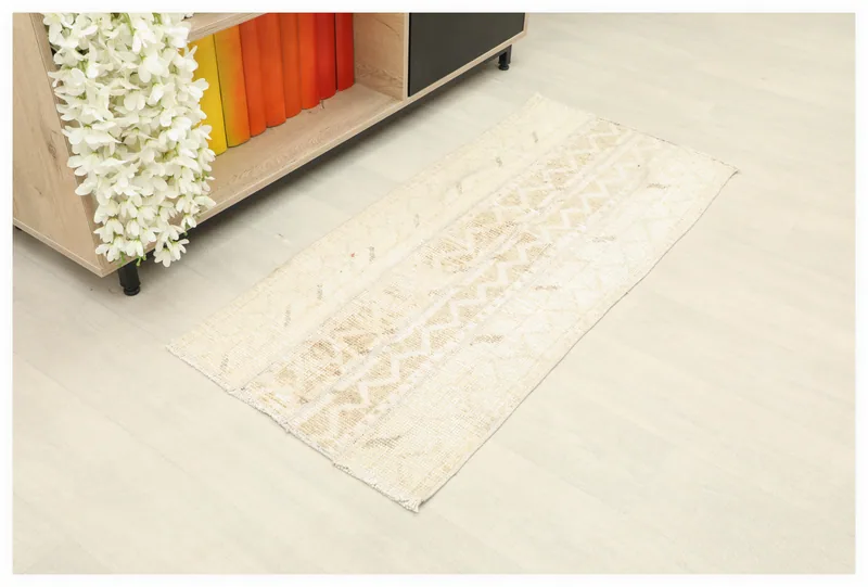 Full top view of the 1'10" x 4'0" tan and beige vintage Anatolian rug on a white background.